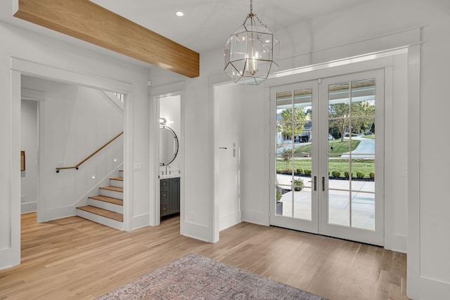 doorway to outside featuring a chandelier, light hardwood / wood-style floors, and french doors