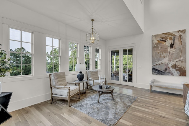 sunroom / solarium featuring french doors and a notable chandelier