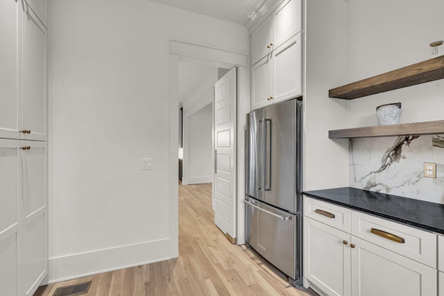 kitchen featuring light hardwood / wood-style floors, backsplash, high end refrigerator, and white cabinetry