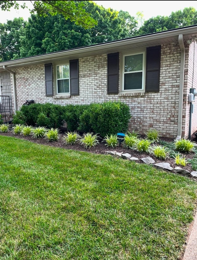 view of side of home with a yard