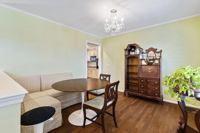 dining room featuring dark hardwood / wood-style flooring, crown molding, a chandelier, and breakfast area