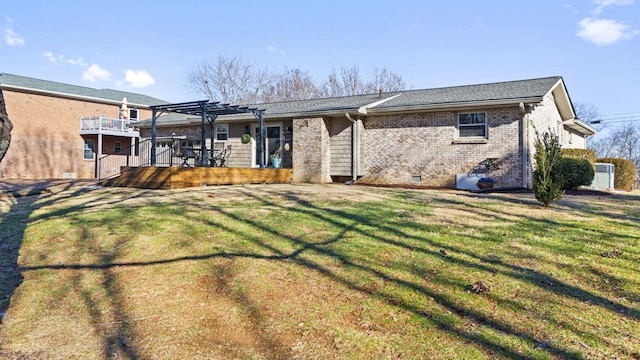 rear view of house with a deck, a lawn, and a pergola