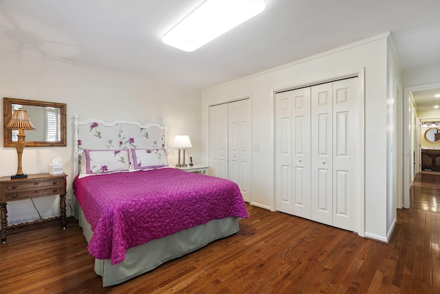 bedroom with multiple closets and dark hardwood / wood-style flooring