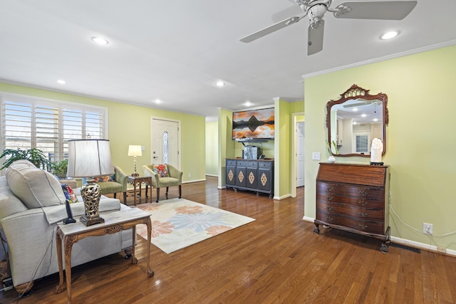 living room featuring ceiling fan, dark hardwood / wood-style floors, and crown molding