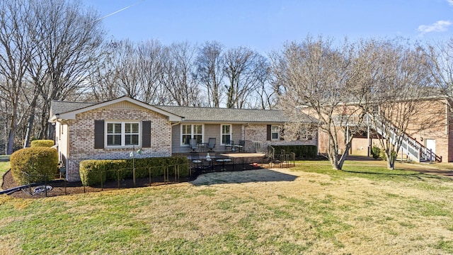 view of front of house featuring a front lawn and a deck