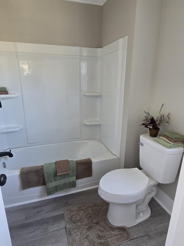 bathroom with toilet, hardwood / wood-style flooring, and washtub / shower combination