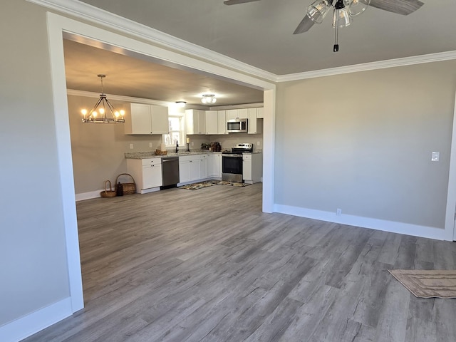 kitchen featuring decorative light fixtures, white cabinets, ornamental molding, and stainless steel appliances