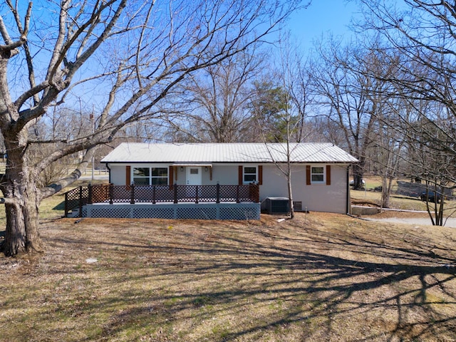 view of front of home featuring metal roof, a porch, and central AC unit