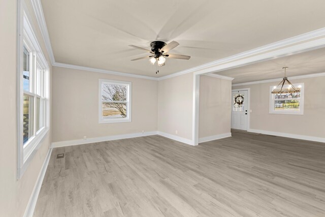 spare room featuring ceiling fan with notable chandelier, visible vents, baseboards, ornamental molding, and light wood finished floors