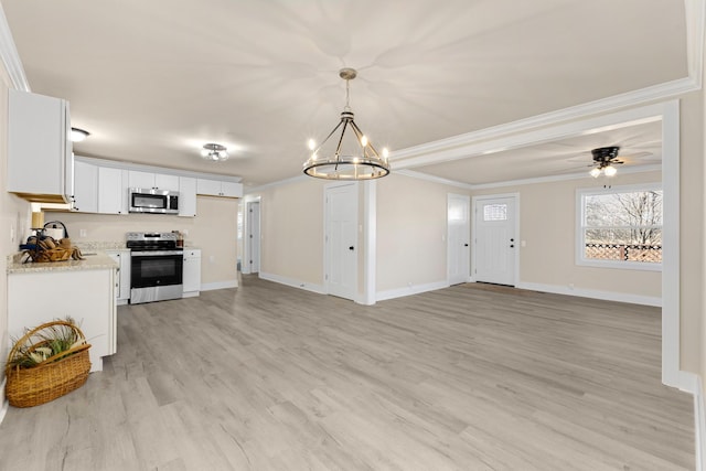 kitchen with stainless steel appliances, hanging light fixtures, light wood-style flooring, ornamental molding, and white cabinetry