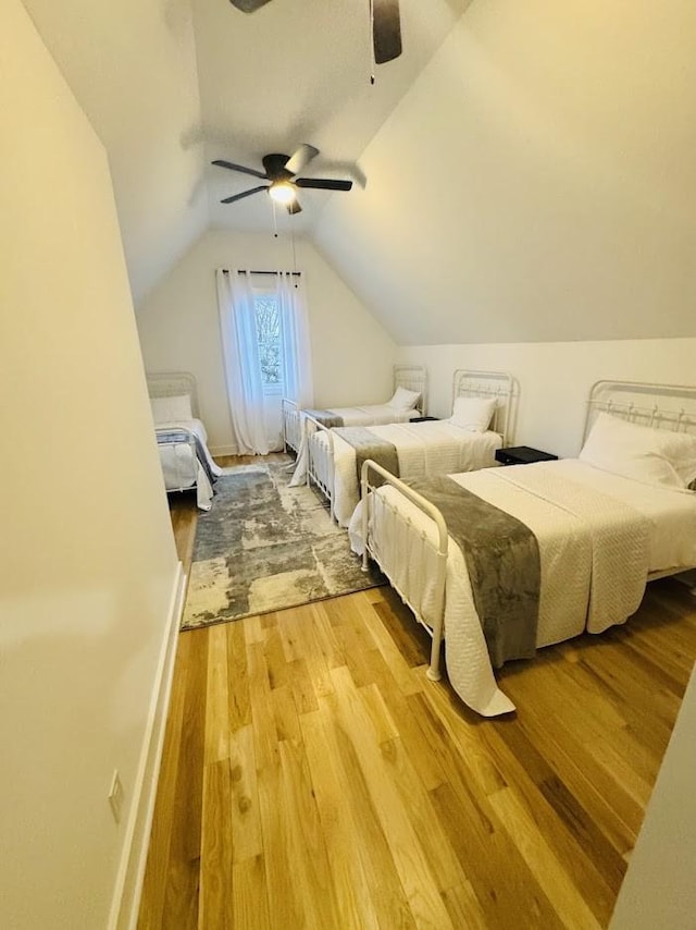 bedroom with vaulted ceiling, ceiling fan, and wood-type flooring