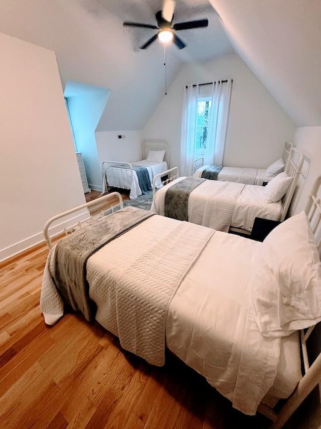 bedroom with ceiling fan, wood-type flooring, and lofted ceiling