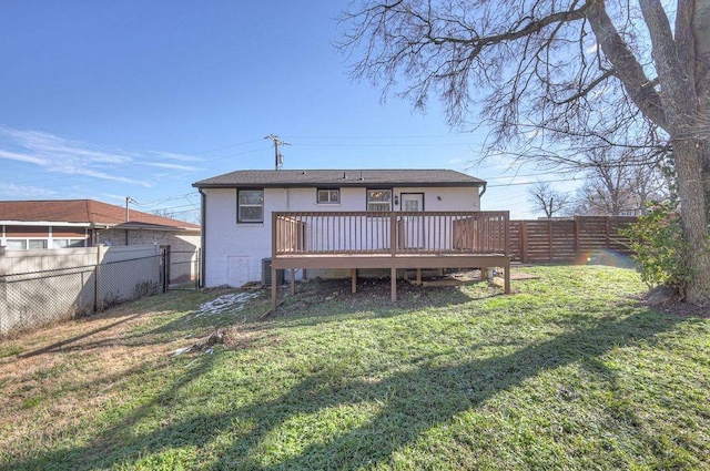 rear view of property featuring a deck and a yard