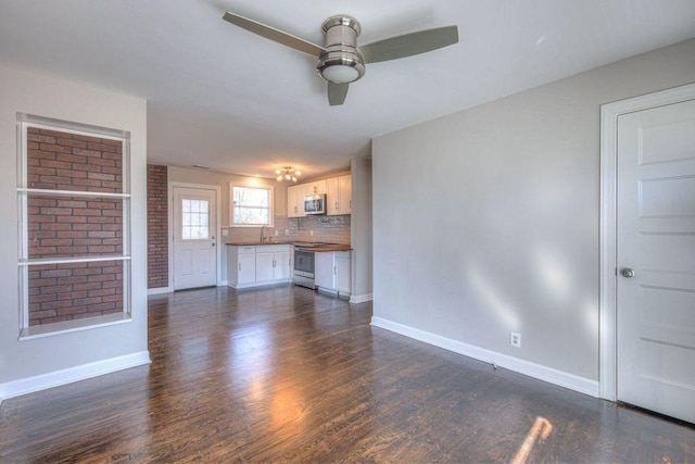 unfurnished living room with ceiling fan and dark hardwood / wood-style flooring