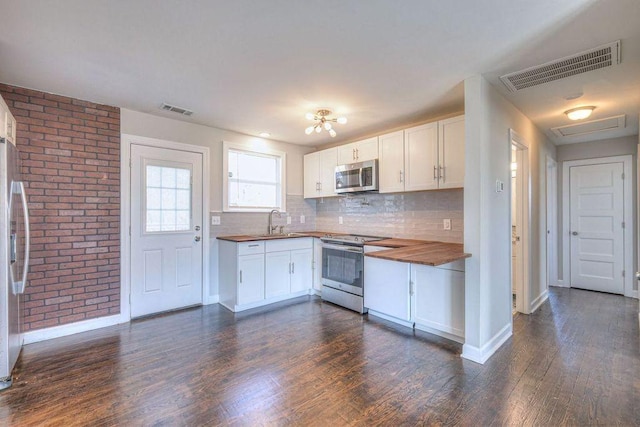 kitchen featuring stainless steel appliances, white cabinetry, wooden counters, and sink