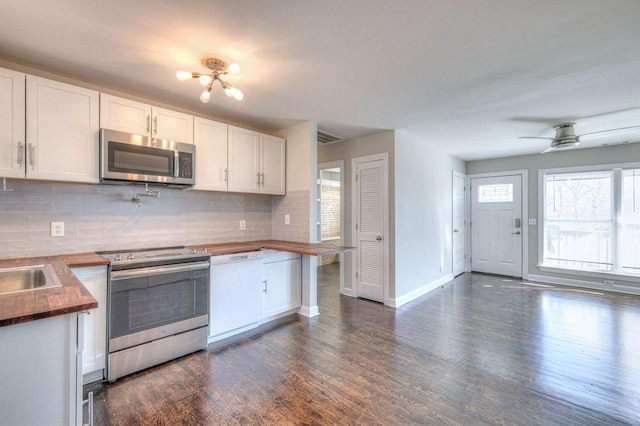 kitchen with tasteful backsplash, white cabinets, ceiling fan, and stainless steel appliances