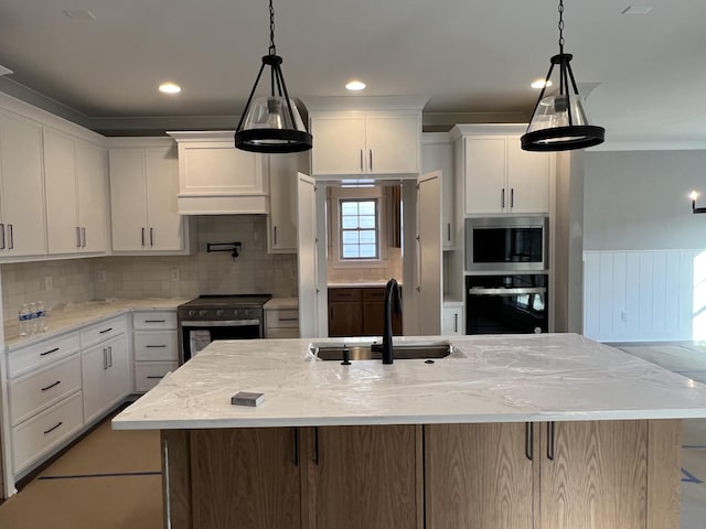 kitchen featuring white cabinetry, appliances with stainless steel finishes, decorative backsplash, and a sink