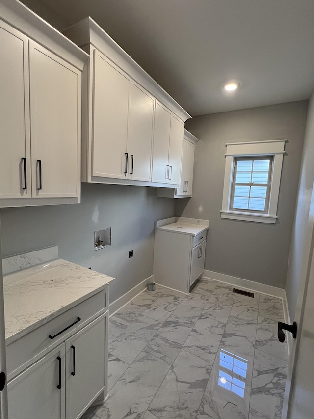 washroom with hookup for a washing machine, visible vents, baseboards, marble finish floor, and cabinet space