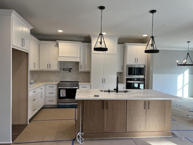 kitchen with premium range hood, a sink, white cabinetry, appliances with stainless steel finishes, and tasteful backsplash