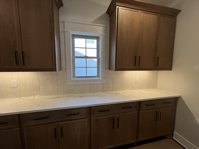 kitchen with light stone counters, baseboards, and decorative backsplash