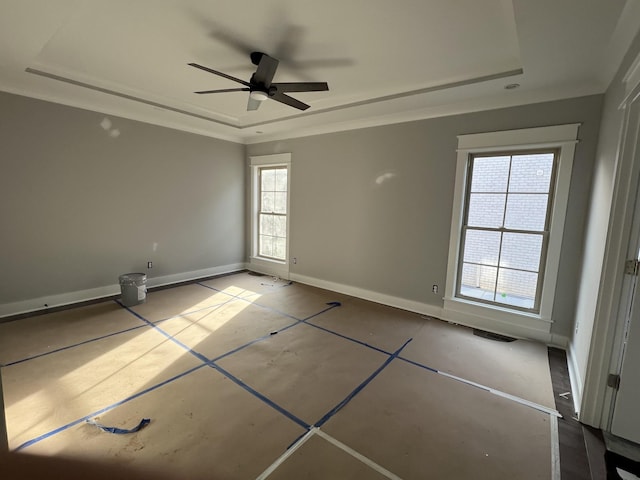 unfurnished room featuring baseboards, visible vents, a tray ceiling, and a ceiling fan