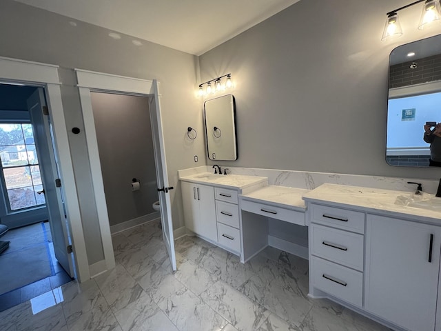 bathroom with marble finish floor, vanity, toilet, and baseboards