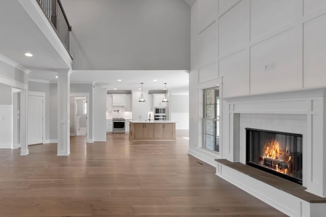 3025 Shady Forest Dr, Murfreesboro, TN 37128 - unfurnished living room with crown molding, a glass covered fireplace, baseboards, dark wood finished floors, and a high ceiling