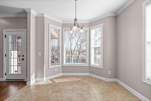 unfurnished dining area featuring crown molding, a healthy amount of sunlight, and a chandelier