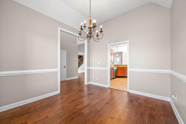 unfurnished dining area with hardwood / wood-style flooring, sink, and vaulted ceiling