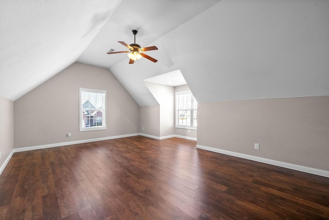 additional living space with dark hardwood / wood-style flooring, a wealth of natural light, ceiling fan, and vaulted ceiling