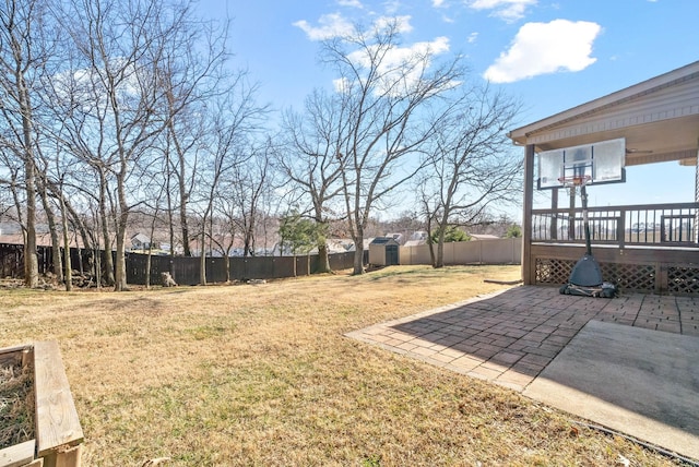 view of yard featuring a storage shed, a wooden deck, and a patio area