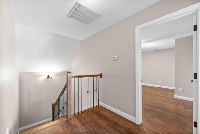 staircase with wood-type flooring and lofted ceiling