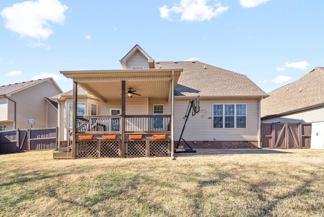 rear view of property featuring a wooden deck, a yard, and ceiling fan