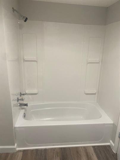 bathroom featuring hardwood / wood-style flooring and bathtub / shower combination