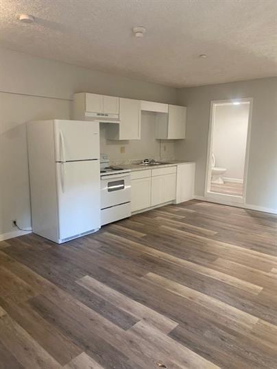 kitchen with sink, white appliances, a textured ceiling, white cabinets, and dark hardwood / wood-style flooring