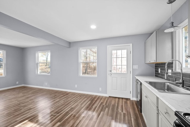 kitchen featuring white cabinetry, backsplash, dishwasher, pendant lighting, and sink