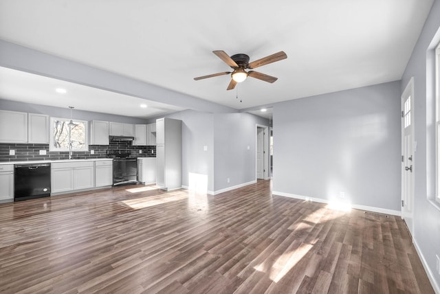 unfurnished living room with ceiling fan, sink, and dark wood-type flooring