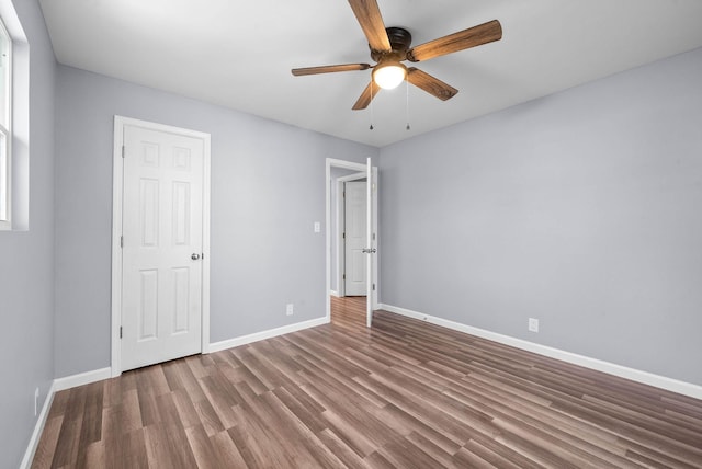 unfurnished bedroom with ceiling fan and dark wood-type flooring