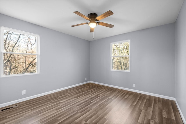 unfurnished room with dark wood-type flooring and ceiling fan