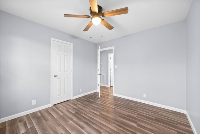 unfurnished bedroom with ceiling fan and dark wood-type flooring