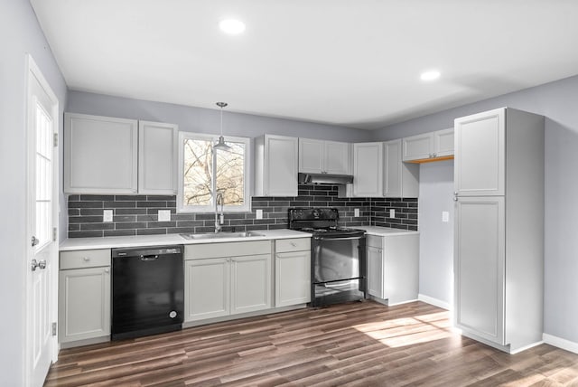 kitchen with backsplash, dark hardwood / wood-style flooring, hanging light fixtures, black appliances, and sink