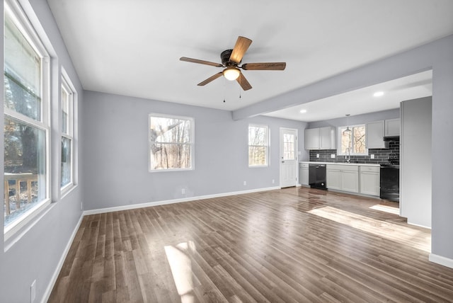 unfurnished living room featuring ceiling fan, dark hardwood / wood-style flooring, and sink