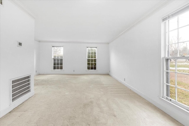 carpeted spare room with heating unit, plenty of natural light, and ornamental molding