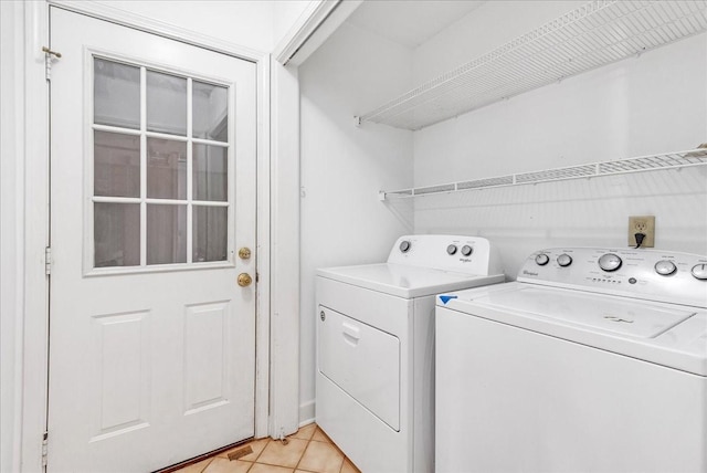 laundry room with light tile patterned floors and washer and dryer