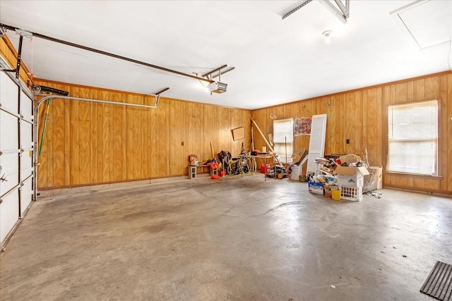 garage featuring a garage door opener and wood walls