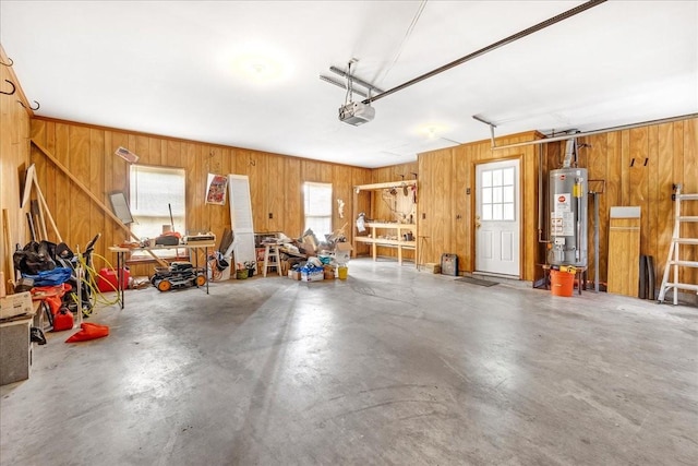 garage with water heater, a garage door opener, and wood walls