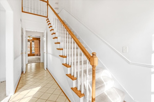 stairway featuring ceiling fan and tile patterned flooring