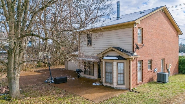 rear view of house featuring central AC unit and a garage