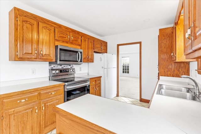 kitchen with light tile patterned floors, sink, and appliances with stainless steel finishes