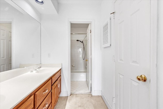 bathroom with tiled shower / bath combo and vanity